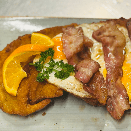 Schnitzel knusprig gebratenen Speckscheiben zwei Spiegeleiern