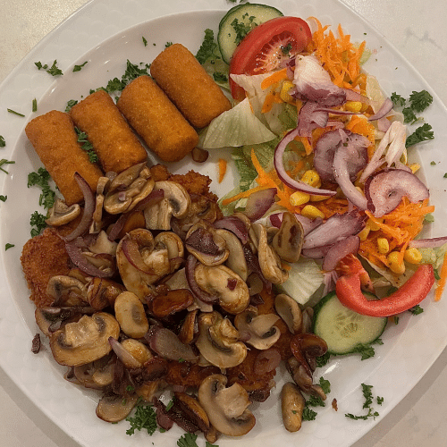 Schnitzel mit gebratenen Zwiebeln und Champignons