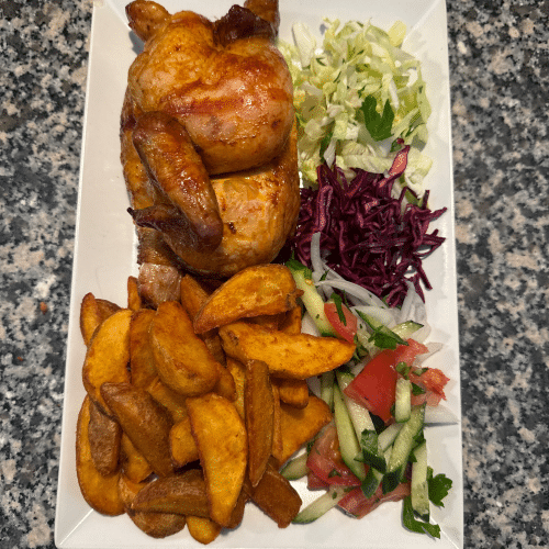 Halbes Hähnchen mit Kartoffelecken und Salat.