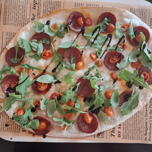 Flammkuchen mit sucuk und cherry tomaten, rucola