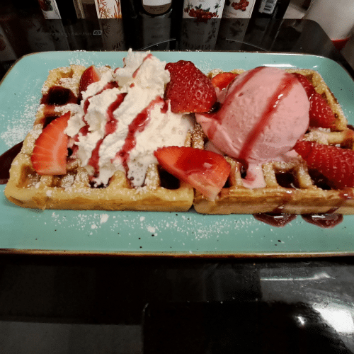 Waffel mit , Waldbeeren, Erdbeer und Vanilleeis, Sahne und Soße