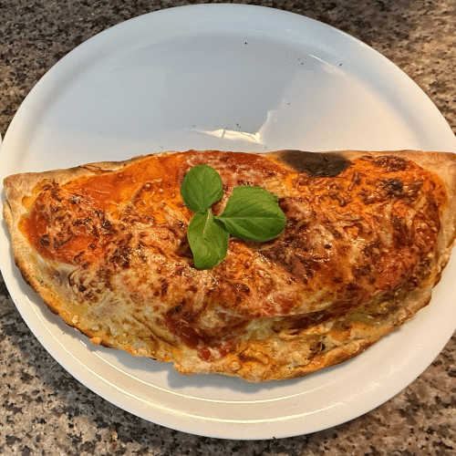 Calzone mit Vorderschinken, Salami, Paprika, Pilze und Oliven