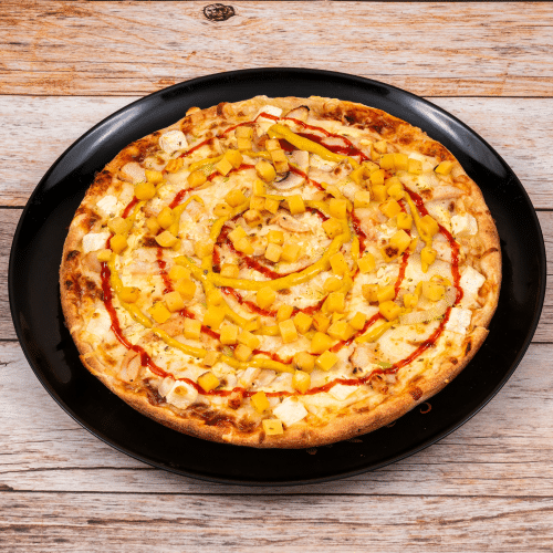 Pizza mit Hähnchen, Ananas, Chiliflocken, Curry und Sauce