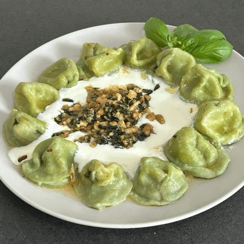 Gekochte Manti mit Käsefüllung in Spinatteig