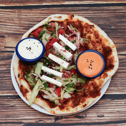Türkische Pizza mit Salat und Weichkäse