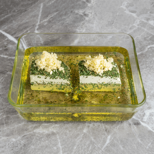 Gewürfelter Weißkäse eingelegt in Kräutern und Chili