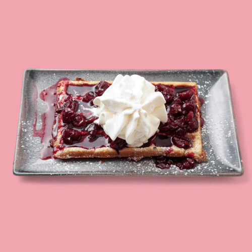 Waffel mit heißen Kirschen und Sahne