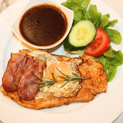 Putensteak mit Putenspeck und Spiegelei