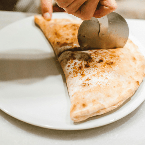 Calzone mit Salami, Schinken, Hackfleisch und Paprika