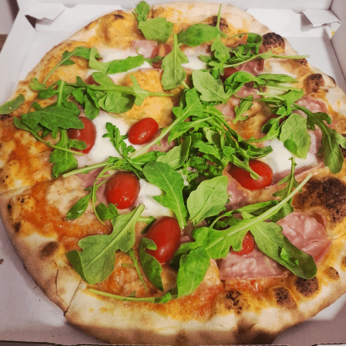 Pizza mit Prosciutto, Parmesan, frischen Tomaten, Rucola und Büffelmozzarella